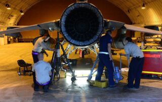 Four technicians repairing an airplane in the hangar of Military Aviation Plant No. 2 in Bydgoszcz, Poland